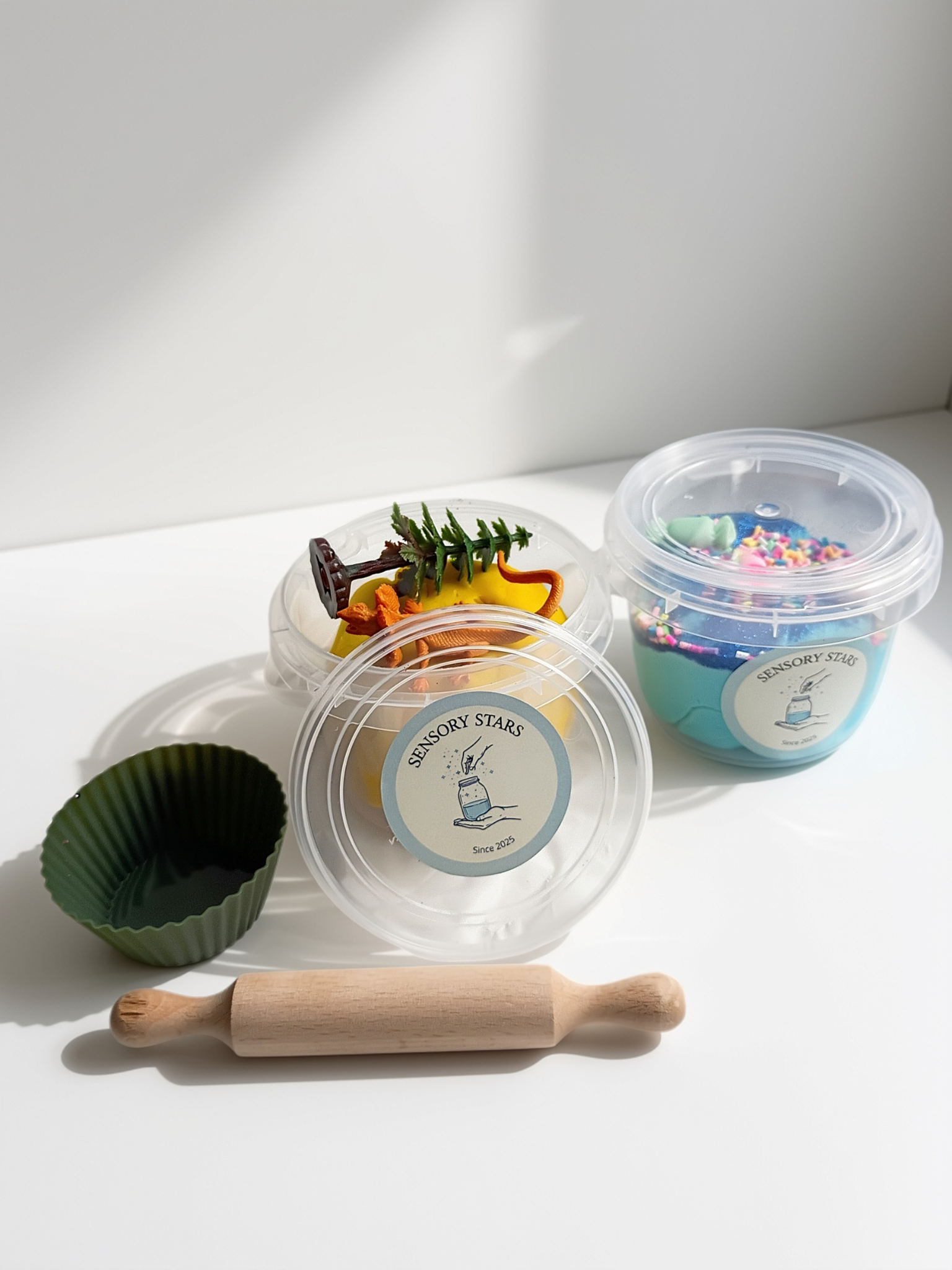 playdough and toys in a jar, rolling pin, muffin mold, blue slime in a jar